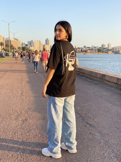 Remera oversize elegant dove, estampado en la espalda, en la Rambla de Montevideo
